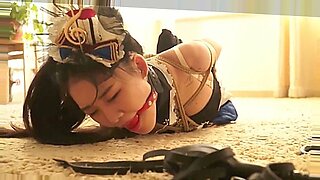 Een schattig Aziatisch meisje ondergaat intense bondage en BDSM in een JAV-video.