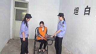 拘束された中国人女性が手錠をいじり、引っ張る。